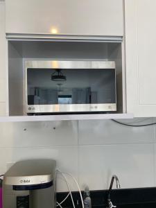 a microwave oven in a kitchen with a sink at Studio em São Paulo 15 min do aeroporto in Sao Paulo