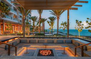 un patio al aire libre con una hoguera y el océano en Waldorf Astoria Cancun en Cancún
