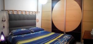 a bedroom with a bed with blue sheets and a wooden headboard at Guest House More in Rijeka