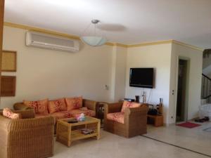 - un salon avec deux canapés et une télévision dans l'établissement Palm Beach Compound Villa, à Ain Sokhna