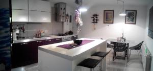 a kitchen with a white counter and a table in it at Guest House More in Rijeka