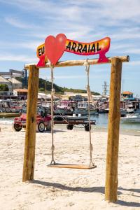 a sign on the beach with a heart on it at Suit's Bella Vista Arraial do Cabo in Arraial do Cabo
