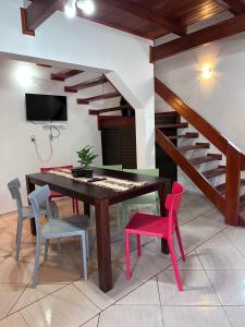 een eetkamer met een tafel en stoelen en een trap bij Reflejos de Luna Llena in Puerto Iguazú