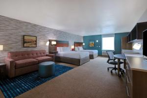 ein Hotelzimmer mit einem Bett und einem Sofa in der Unterkunft Home2 Suites By Hilton Barstow, Ca in Barstow