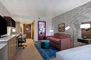 een hotelkamer met een bed, een stoel en een bureau bij Home2 Suites By Hilton Barstow, Ca in Barstow