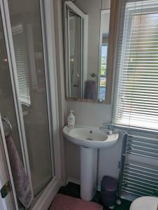 uma casa de banho com um lavatório, um chuveiro e um espelho. em Caravan Swanage Bay View Holiday Park Dorset Amazing Location em Swanage