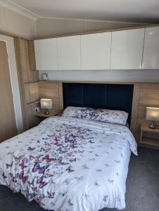 um quarto com uma cama grande e uma cabeceira azul em Caravan Swanage Bay View Holiday Park Dorset Amazing Location em Swanage