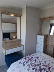 a bedroom with a bed and a mirror at Caravan Swanage Bay View Holiday Park Dorset Amazing Location in Swanage