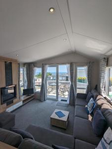 a living room with a couch and a television at Caravan Swanage Bay View Holiday Park Dorset Amazing Location in Swanage