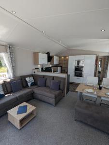 un soggiorno con divano e tavolo di Caravan Swanage Bay View Holiday Park Dorset Amazing Location a Swanage