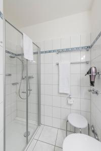 een badkamer met een douche, een toilet en een wastafel bij Am Grooten Steen - Seehund in Cuxhaven