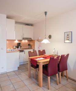een keuken en eetkamer met een houten tafel en stoelen bij Am Grooten Steen - Seehund in Cuxhaven