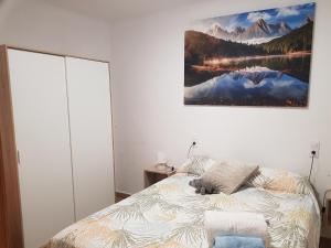 ein Schlafzimmer mit einem Bett und einem Gemälde an der Wand in der Unterkunft Fantàstic Pis a Oliana Alt Urgell Lleida Wifi in Oliana