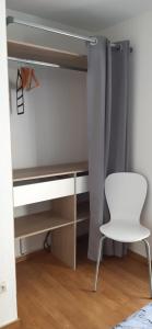 a closet with a desk and a white chair at L'Appart avec terrasse - centre historique in Barr +24 photos