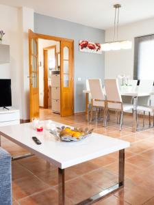 a living room with a white table with a bowl of fruit on it at Casa Mimi - your perfect family getaway in Corralejo