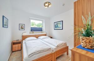 een bed in een kamer met een raam en een tafel bij Am Grooten Steen - Seehund in Cuxhaven