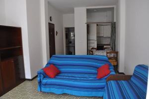 ein Wohnzimmer mit einem blauen Sofa und roten Kissen in der Unterkunft Monolocale n°5 vicino al centro e con dehor in Laigueglia