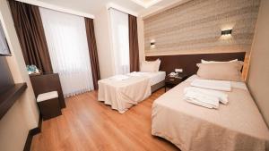 伊斯坦堡的住宿－Bellezza Hotel，酒店客房,设有两张床和两张桌子