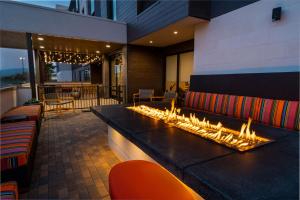 a lobby with a fireplace in the middle of a building at Home2 Suites Corona, Ca in Corona