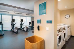 a gym with a washing machine and exercise bikes at Home2 Suites Corona, Ca in Corona