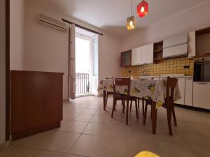a kitchen with a table and chairs and a kitchen with a window at Casa Igea in Siracusa
