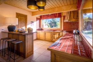 duża kuchnia z ladą i oknem w obiekcie Chalet Antigone - OVO Network w mieście Saint-Jean-de-Sixt