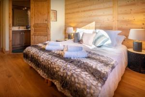 sypialnia z dużym łóżkiem z niebieskimi poduszkami w obiekcie Chalet Antigone - OVO Network w mieście Saint-Jean-de-Sixt +18 zdjęć