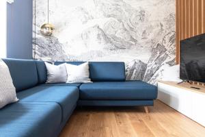 eine blaue Couch in einem Wohnzimmer mit einem Gemälde in der Unterkunft Ferienhaus im Altstadtgässchen mit 3 Badezimmern in Quedlinburg