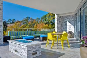 un patio con sillas amarillas, mesa y vistas en Home2 Suites By Hilton Savannah Midtown, Ga en Savannah