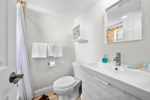 a white bathroom with a toilet and a sink at Unique Studio w Parking in Top Location in Atlanta