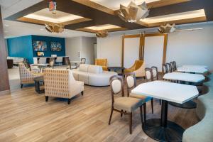 uma sala de espera com mesas e cadeiras em Homewood Suites by Hilton Baltimore - Arundel Mills em Hanover