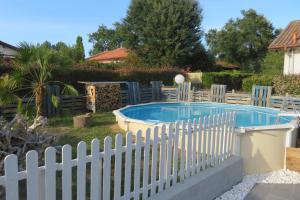 una valla blanca alrededor de una piscina en Maison familiale avec piscine hors sol, en Saint-Vincent-de-Tyrosse