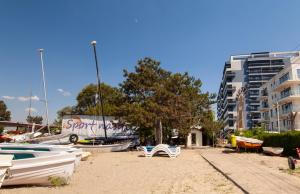 a sandy beach with boats on it with a building at Aparthotel Mirage Sunset - zona Hotel Rex in Mamaia