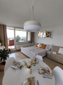 a living room with a white table and a couch at Pools, Sauna und Balkon mit Panoramablick in Sankt Englmar