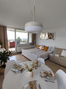 un soggiorno con un tavolo bianco e un divano di Pools, Sauna und Balkon mit Panoramablick a Sankt Englmar