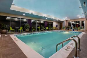 a pool in a hotel lobby with tables and chairs at Home2 Suites By Hilton Lexington Hamburg in Lexington