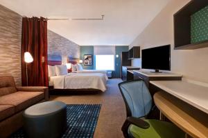 a hotel room with a bed and a television at Home2 Suites By Hilton Lexington Hamburg in Lexington