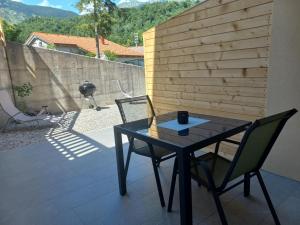 a black table and two chairs on a patio at Hiša za Gradom in Kobarid