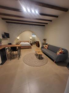 a living room with a couch and a bed and a table at Coucou Boutique Studio in Ios Chora