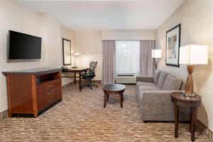 a hotel room with a couch and a tv at Hilton Garden Inn Hanover Arundel Mills, MD in Hanover
