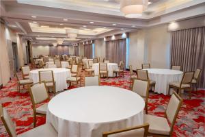 una sala de banquetes con mesas y sillas blancas en Hilton Garden Inn Hanover Arundel Mills, MD en Hanover