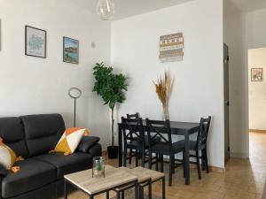 a living room with a couch and a table and chairs at Au gîte d'Artigues in Pont-du-Casse
