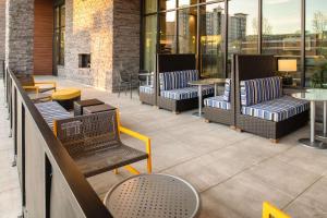 un patio con sillas, mesas y ventanas en Home2 Suites By Hilton Boise Downtown en Boise