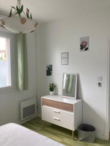 a bedroom with a dresser with a mirror on it at Au gîte d'Artigues in Pont-du-Casse