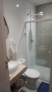 ein Bad mit einem WC und einer Glasdusche in der Unterkunft Suit's Bella Vista Arraial do Cabo in Arraial do Cabo