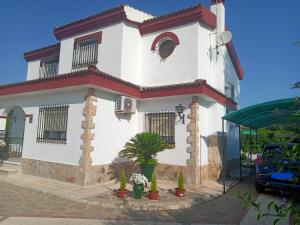 une maison blanche avec des plantes devant elle dans l'établissement El rincón de Dory, à Martos