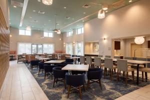 uma sala de jantar com mesas, cadeiras e janelas em Homewood Suites By Hilton Myrtle Beach Coastal Grand Mall em Myrtle Beach