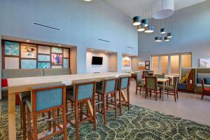 a lobby with a long bar with chairs and tables at Hampton Inn & Suites Borger in Borger