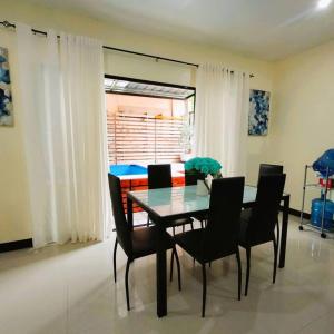 a dining room with a glass table and black chairs at Stellar Homesharing 1 in Davao City