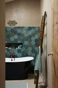 ein Badezimmer mit einer Badewanne und einer blau gefliesten Wand in der Unterkunft Maisons 322 - L'Insolite in Le Bois-Plage-en-Ré